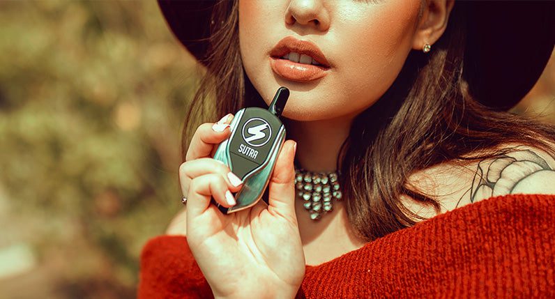 Woman with hat holding Sutra Squeeze outside